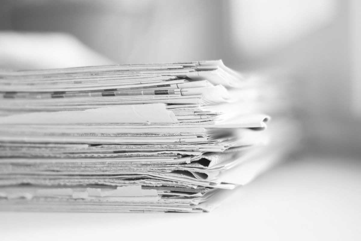 Lots of newspapers, magazines and journals pages folded and stacked in pile, selective focus on paper with blurred background. Could be used for news, information and communication concept       