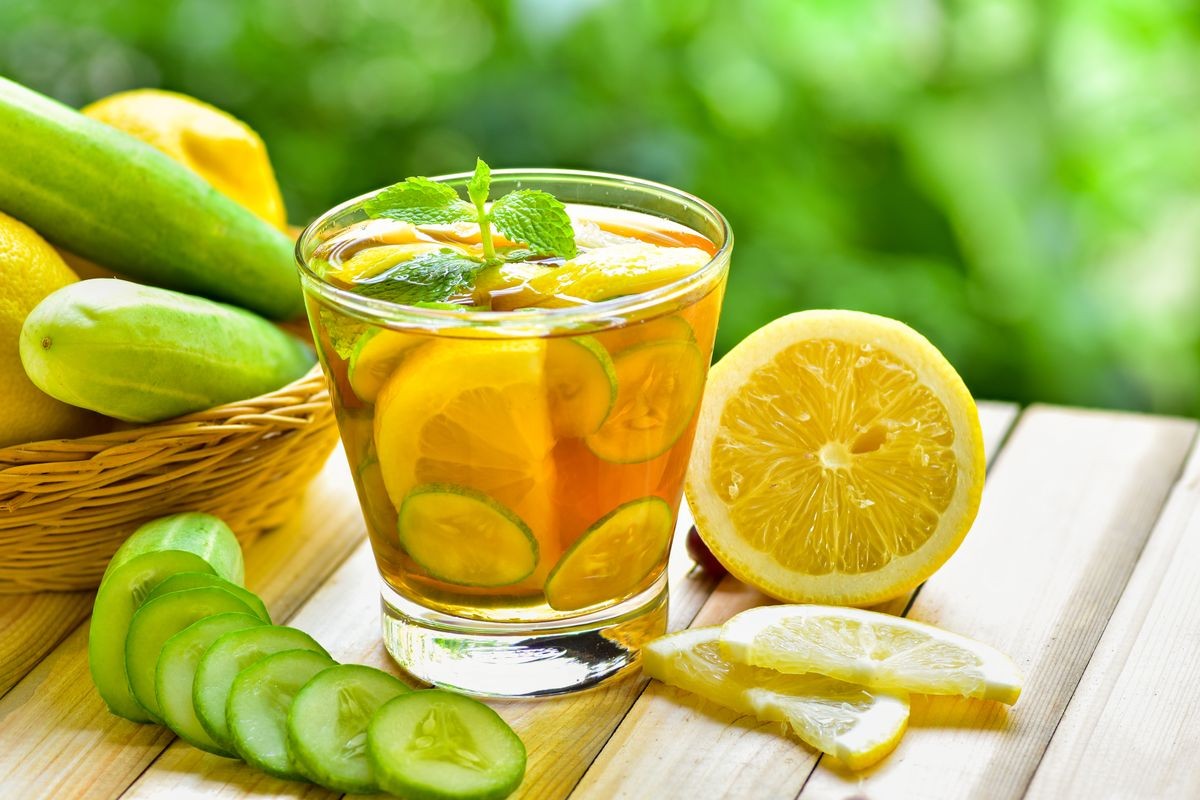 Detox water drink with lemon and cucumber honey in glass